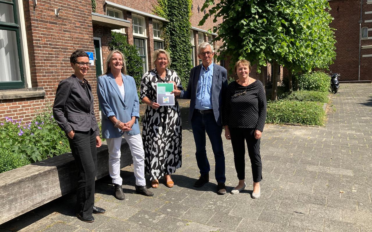 Wethouder Inge Jongman (midden) krijgt het evaluatierapport over het Overweeghuis in Groningen overhandigd.