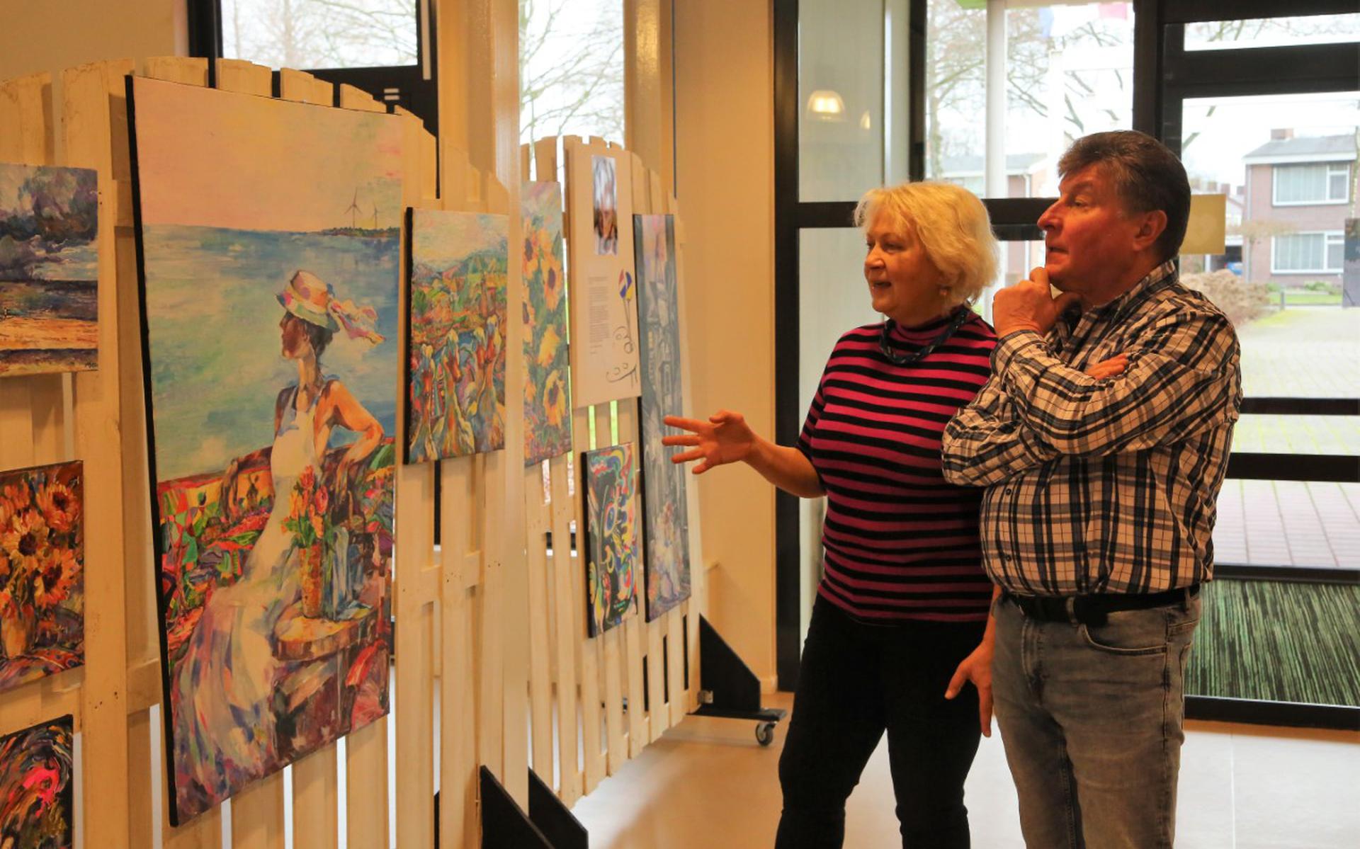 Natalia Antiushyna en haar man Oleg bekijken de schilderijen.