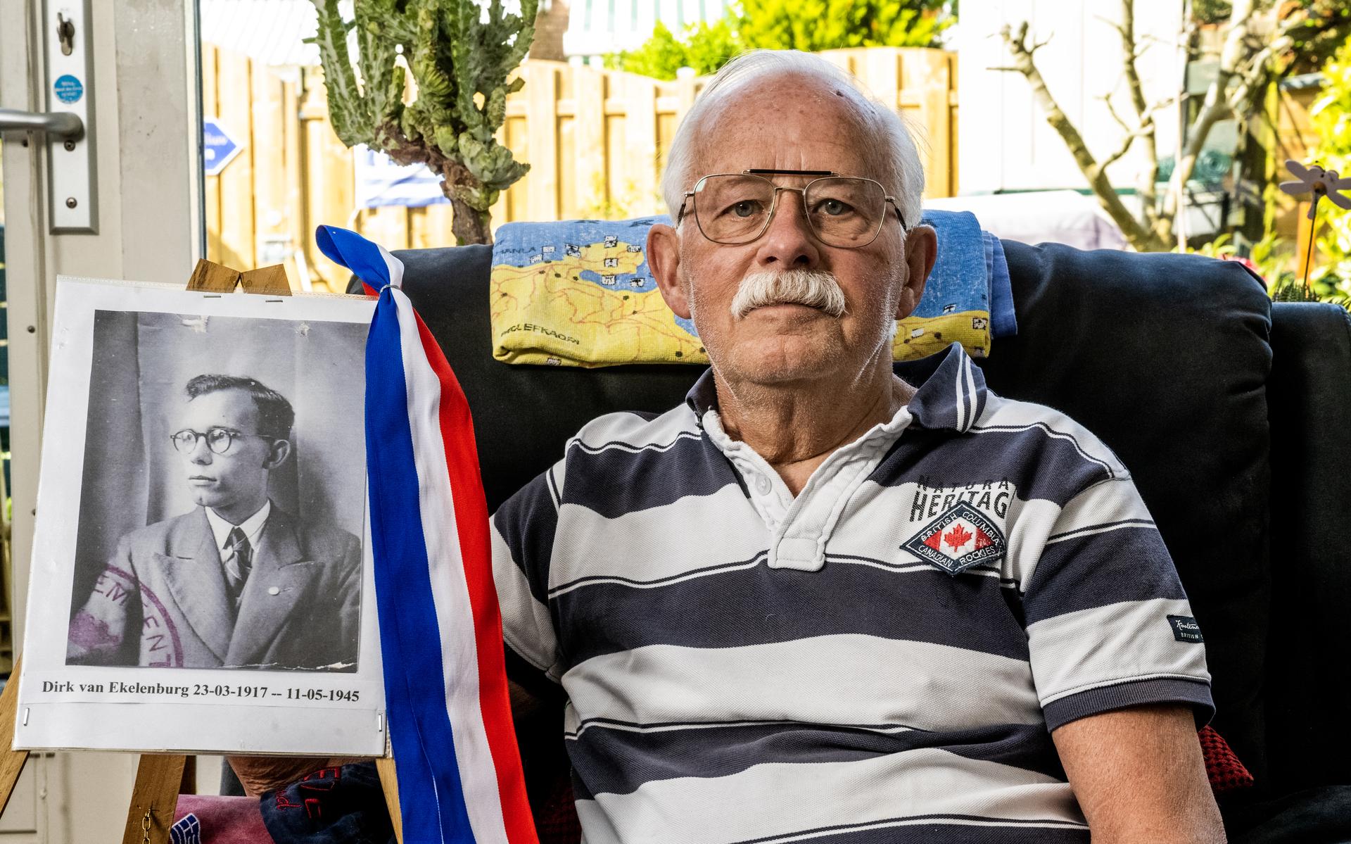 Hans van Ekelenburg (79) met naast hem een foto van zijn vader, die verzetsstrijder was en in mei 1945 overleed.