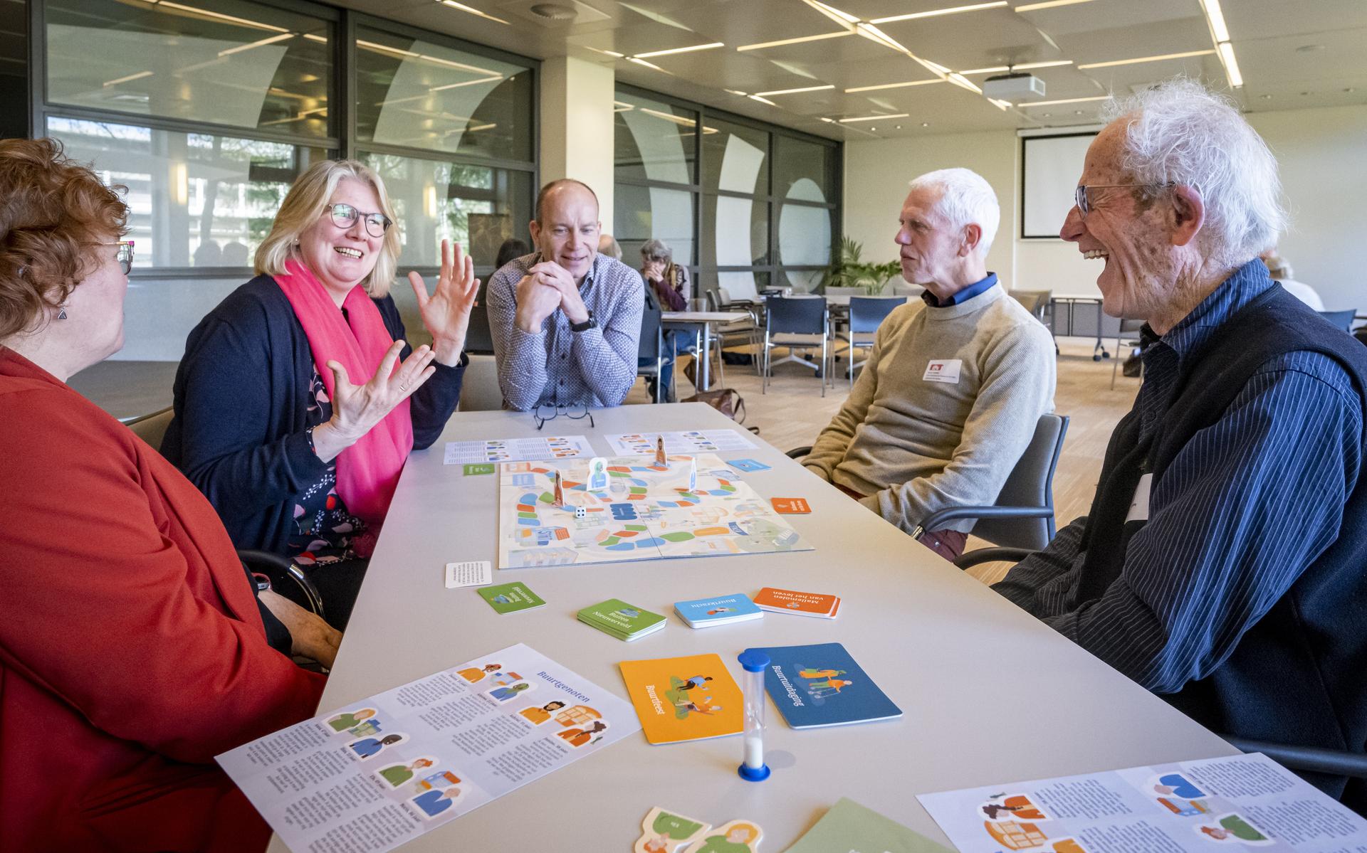 Tijdens het symposium 'Ouder worden in Drenthe' spelen deelnemers een spel met vragen over ouder worden. De spelers zijn druk aan het praten en discussiëren. Vanaf links: Ria Haan, Monique Bodegom, Ramon Snippe, Rinus Vaartjes en Janpiet van den Berg.