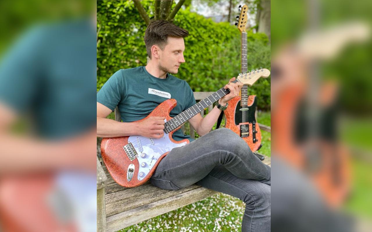 Viktor Mei met de nieuwe stempotloodgitaar in zijn handen en het eerste exemplaar naast zich. Viktor Mei met de nieuwe stempotloodgitaar in zijn handen en het eerste exemplaar naast zich.
