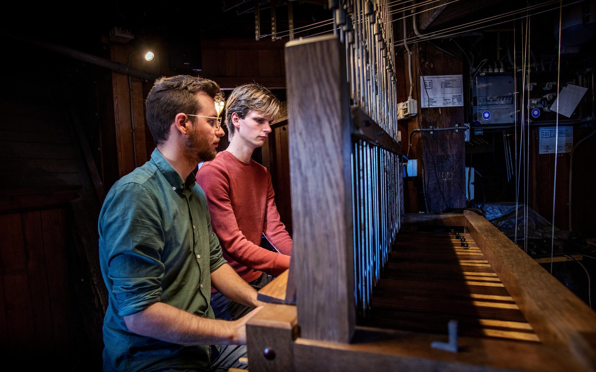 Maurits Bunt (links) bespeelt het carillon van de Martinitoren.