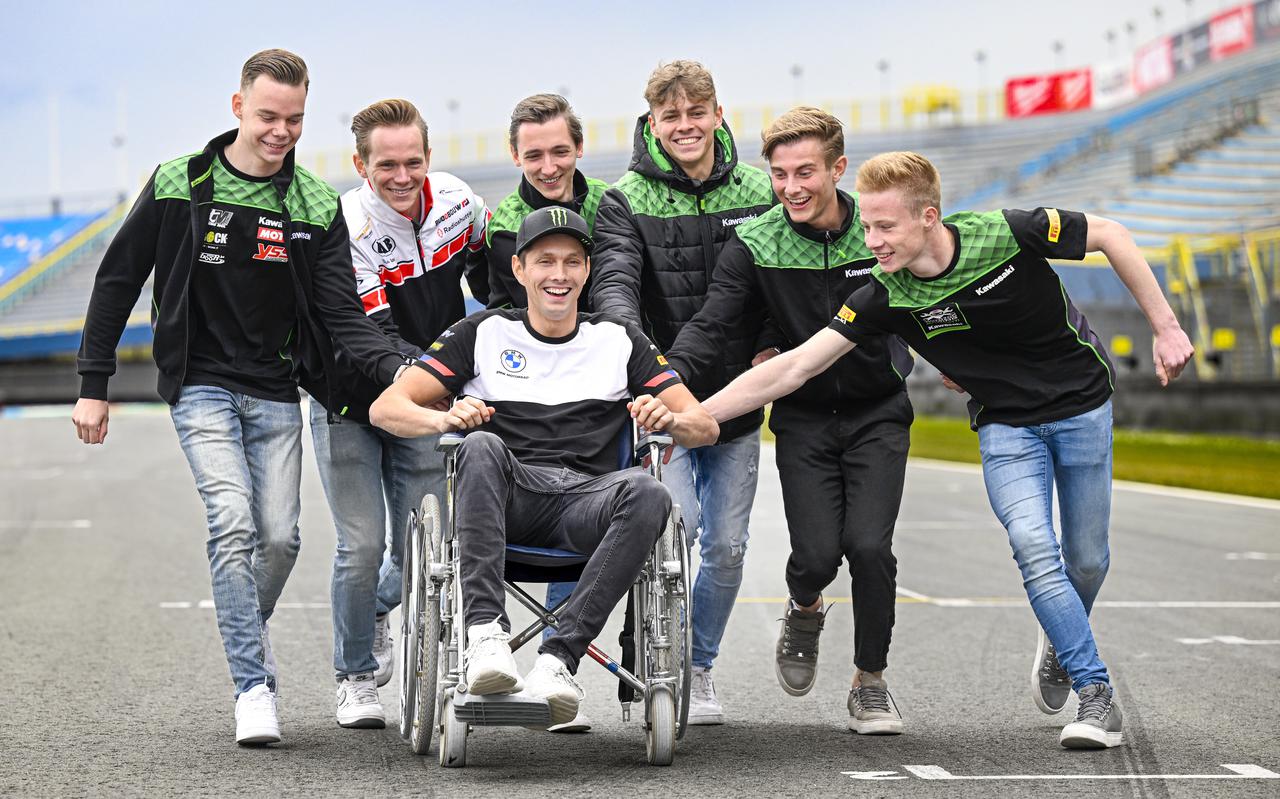 Michael van der Mark (in rolstoel) wordt omringd door collega-coureurs op het TT Circuit in Assen.