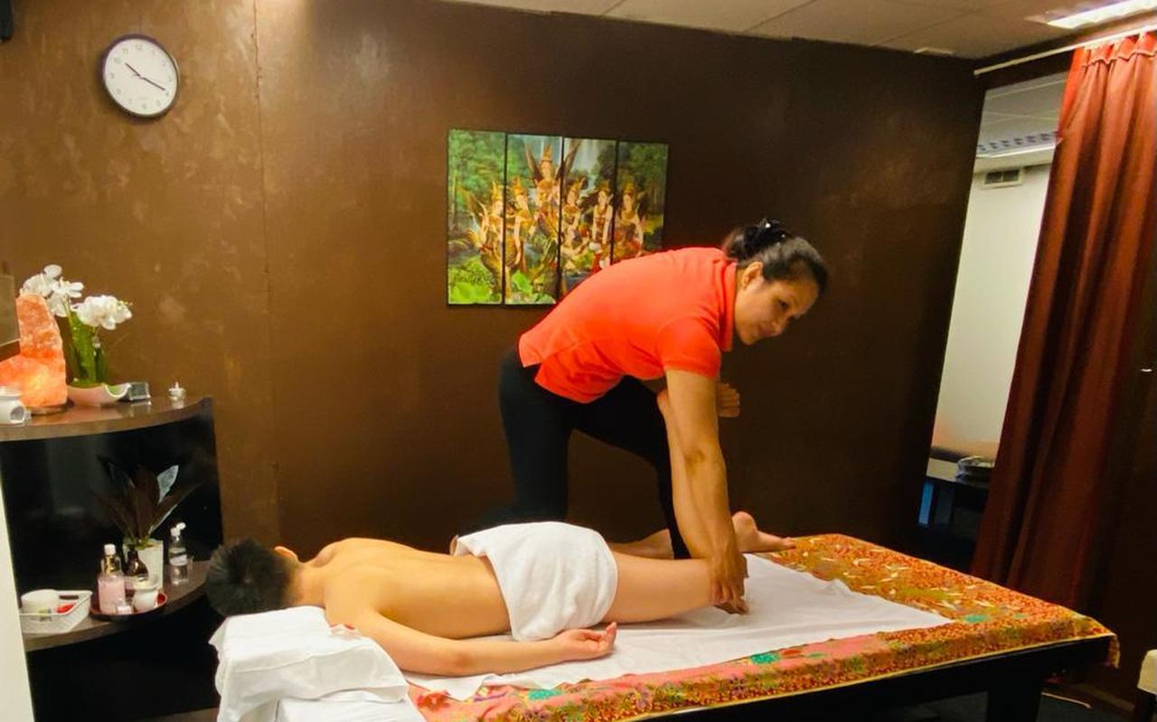 Linda Yimpra geeft een massage. Ze heeft een bordje bij haar nieuwe salon gehangen om duidelijk te maken dat dit het enige is wat er wordt gegeven. Linda Yimpra geeft een massage. Ze heeft een bordje bij haar nieuwe salon gehangen om duidelijk te maken dat dit het enige is wat er wordt gegeven.