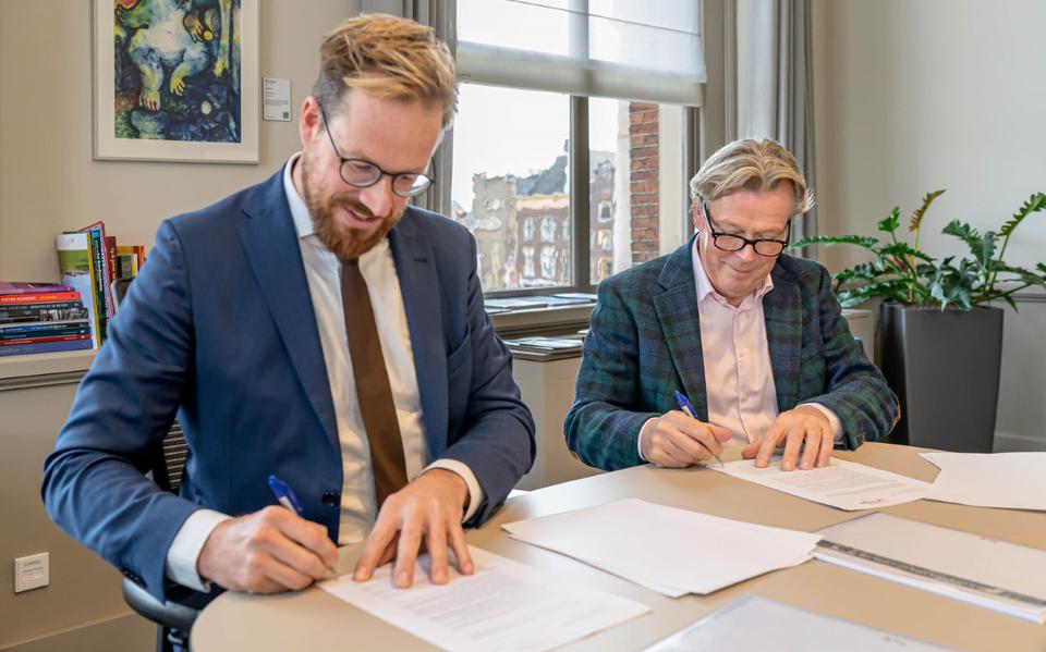 Wethouder Rik van Niejenhuis (l) en vastgoedondernemer Jaap ten Hoor ondertekenen het voorlopige contract voor het appartementencomplex aan de Friesestraatweg 175.