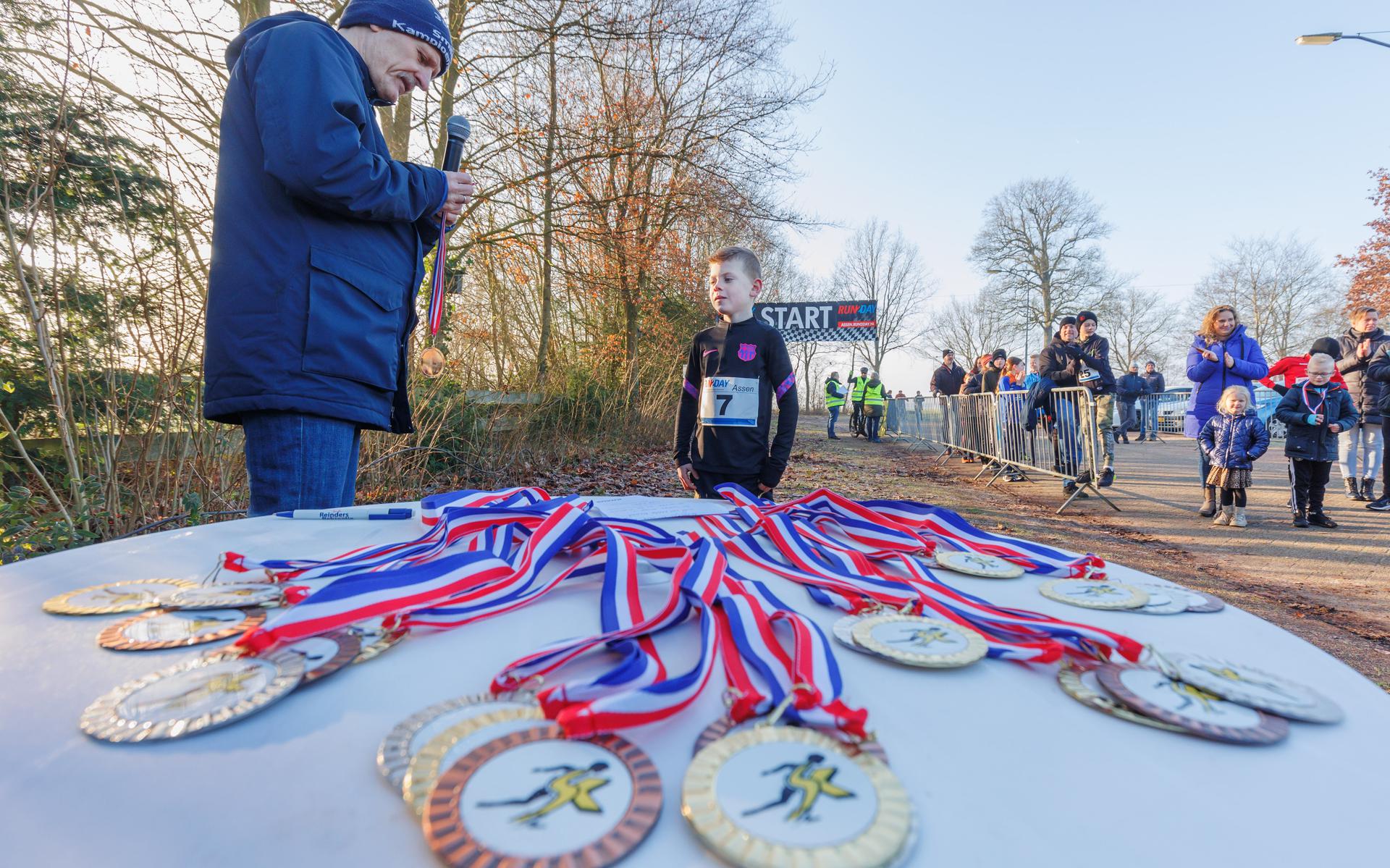 Een piepjonge hardloper haalt zijn medaille op na de Smildeger Crossloop, onderdeel van de Smildeger Kampioenschappen die dit weekend plaatsvonden.