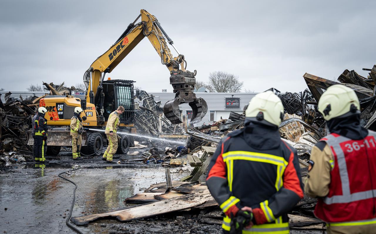De brand smeult nog na. Met een kraan worden de restanten van de loods opgetild zodat de brandweer bij de vuurhaard kan komen. De brand smeult nog na. Met een kraan worden de restanten van de loods opgetild zodat de brandweer bij de vuurhaard kan komen.