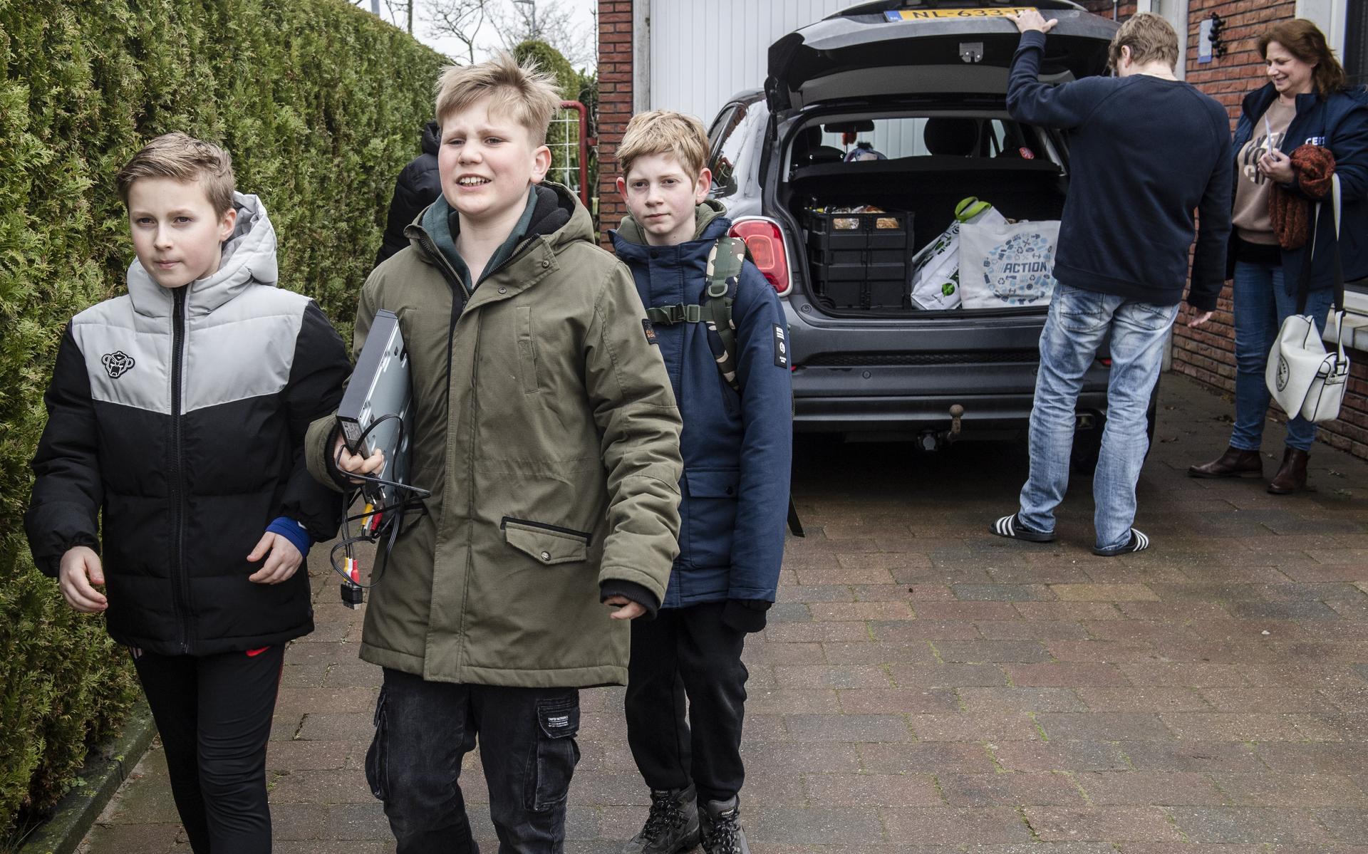 Leerlingen van Kindcentrum Noord in Delfzijl doen mee aan de E-waste Race. Maurice (11), Merijn (12) en Daan (13) slaan direct toe als een auto op de oprit rijdt.