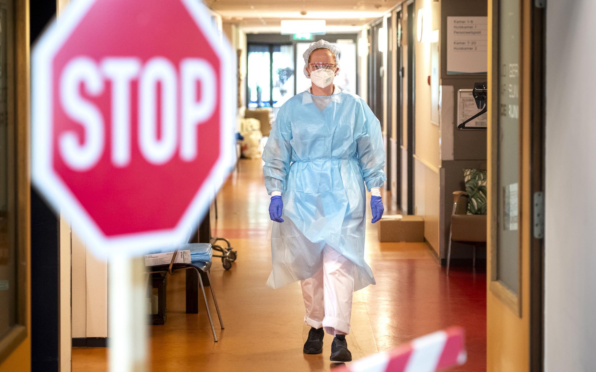 Een medewerkster draagt beschermende kleding op de covidafdeling in verpleeghuis De Horst in Emmen.