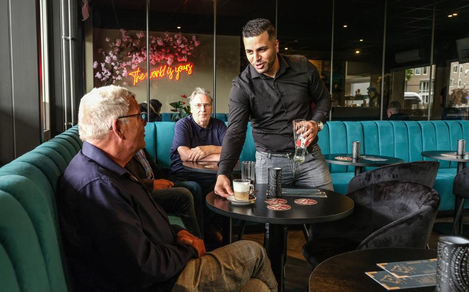 Monty Albadawi serveert koffie aan zijn voorganger Bert Hofman die met twee van zijn vroegere stamgasten een kijkje neemt in het nieuwe eetcafé op Station Noord.