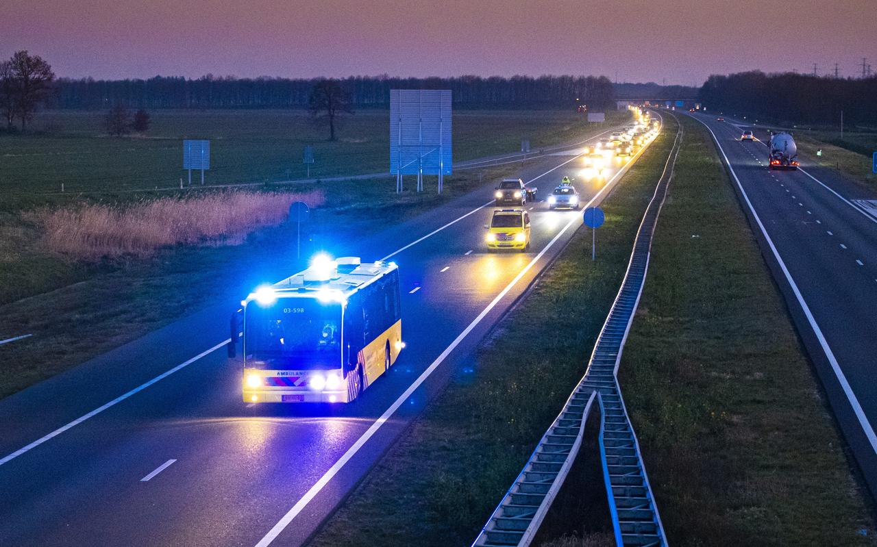 Een ambulancebus met coronapatiënten uit Brabant rijdt onder begeleiding van politie over de snelweg A28 richting Groningen. COPYRIGHT MARCEL JURIAN DE JONG Een ambulancebus met coronapatiënten uit Brabant rijdt onder begeleiding van politie over de snelweg A28 richting Groningen. COPYRIGHT MARCEL JURIAN DE JONG