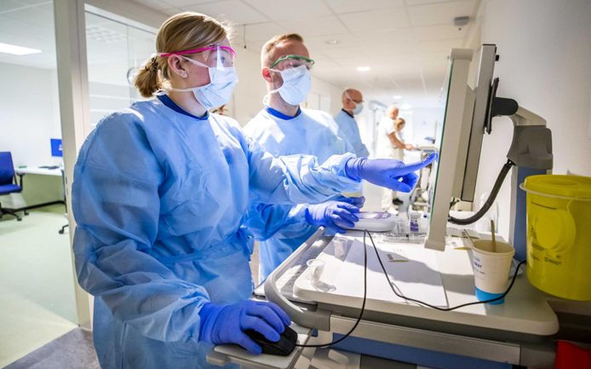 Verpleegkundigen maken medicijnen gereed voor een coronapatient op de verpleegafdeling voor coronapatienten van het HMC Westeinde ziekenhuis.