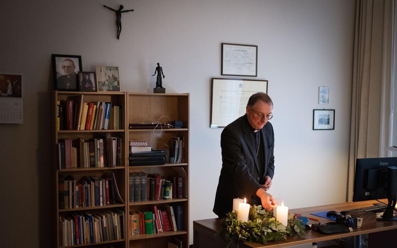Bisschop Van den Hout steekt in zijn kantoor de Adventskaars aan