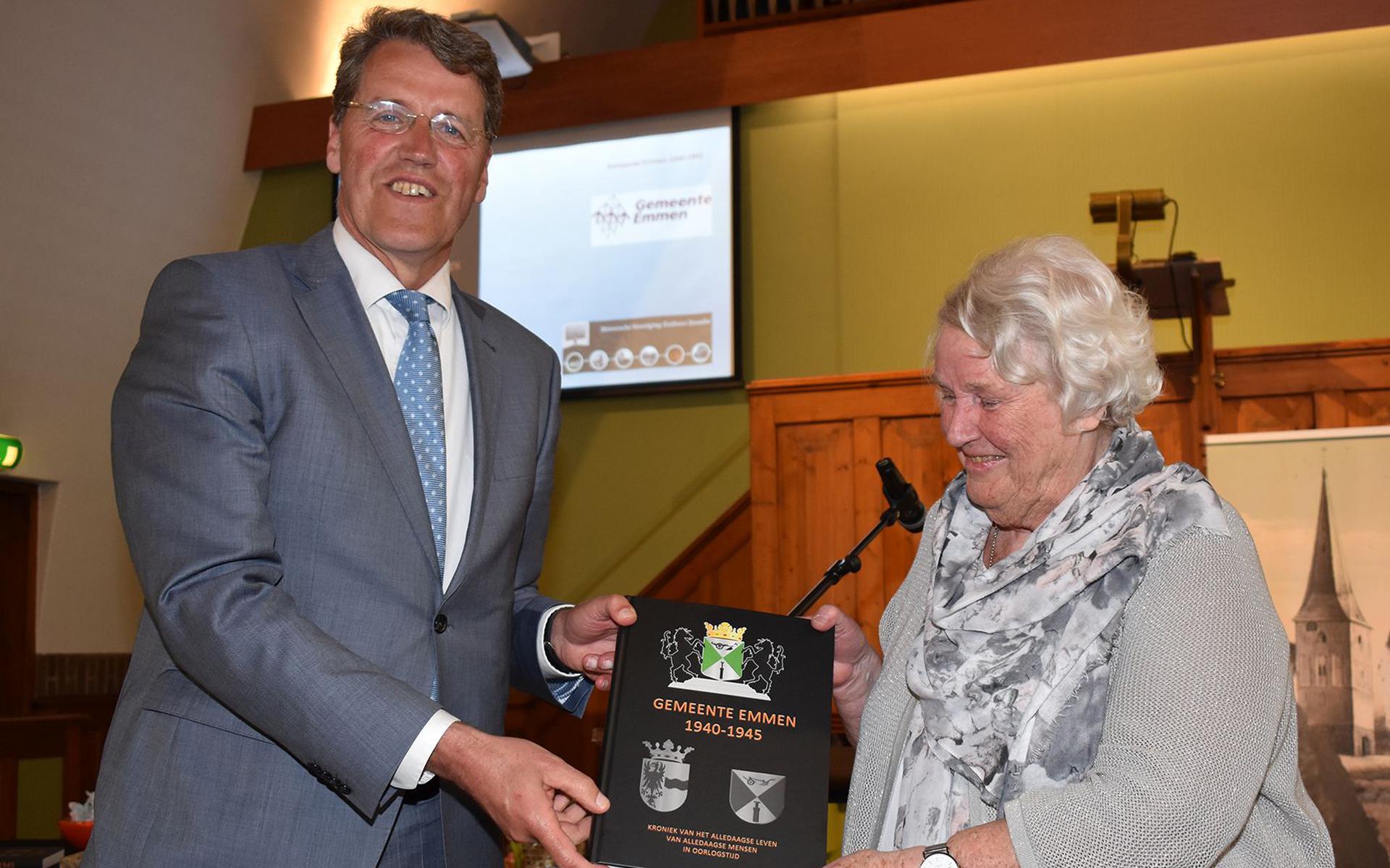 Schrijfster Sis Hoek-Beugeling reikt haar boek uit aan burgemeester Eric van Oosterhout.