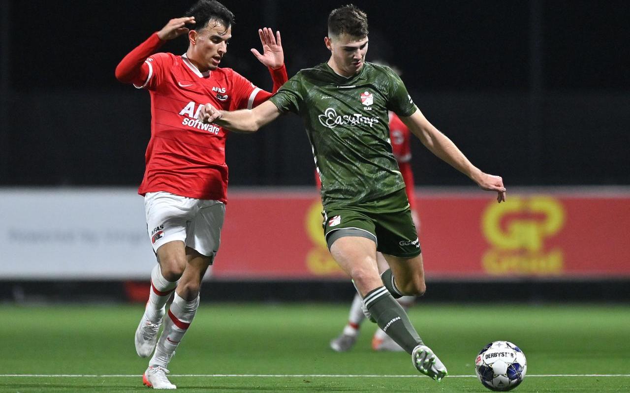 Mohammed Taabouni van Jong AZ kijkt toe hij FC Emmen-speler Jari Vlak uithaalt voor een schot. Mohammed Taabouni van Jong AZ kijkt toe hij FC Emmen-speler Jari Vlak uithaalt voor een schot.