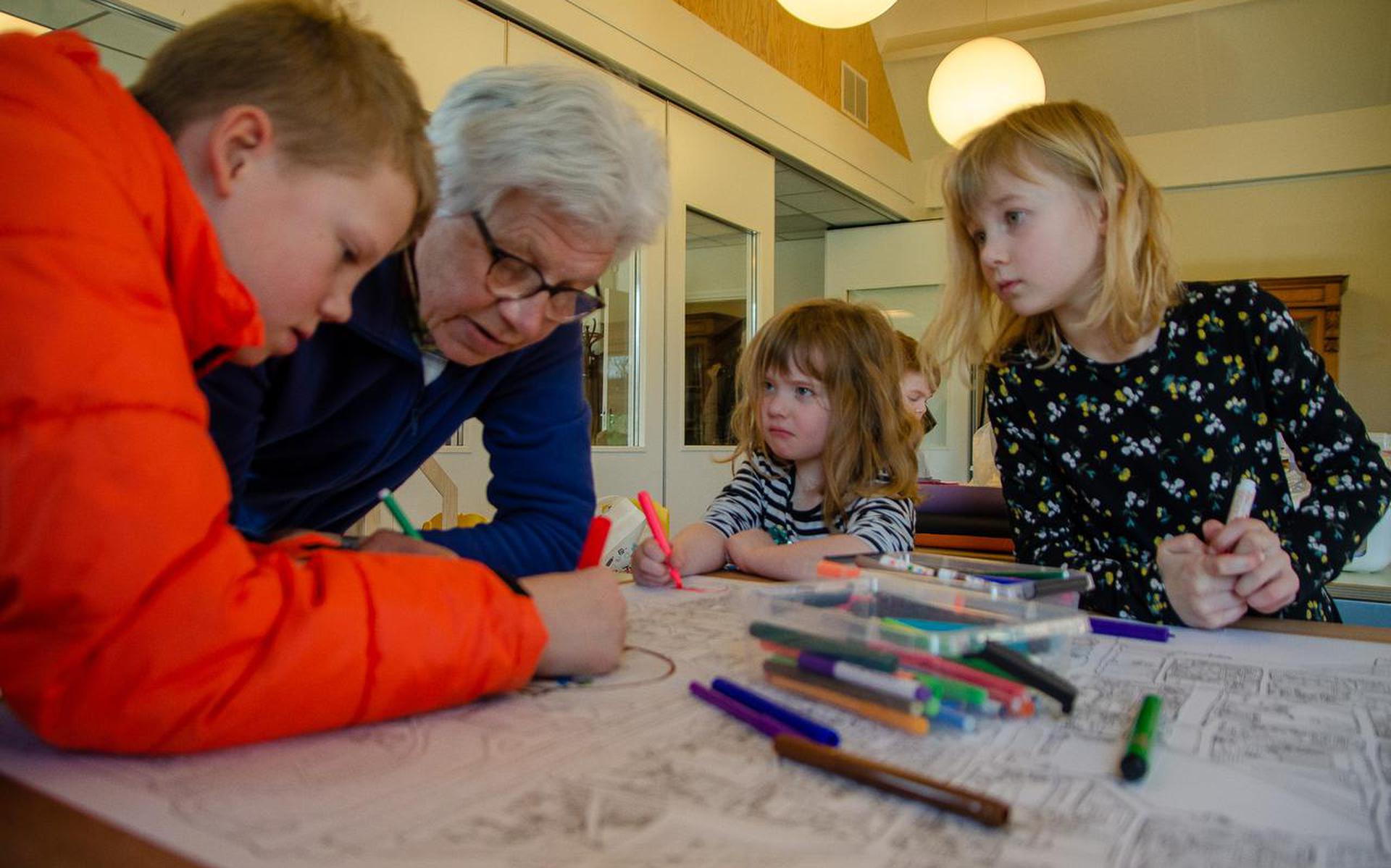Sven en zijn oma nemen een hoekje van de grote tekening voor hun rekening. Sanna en Marrit een andere hoek.