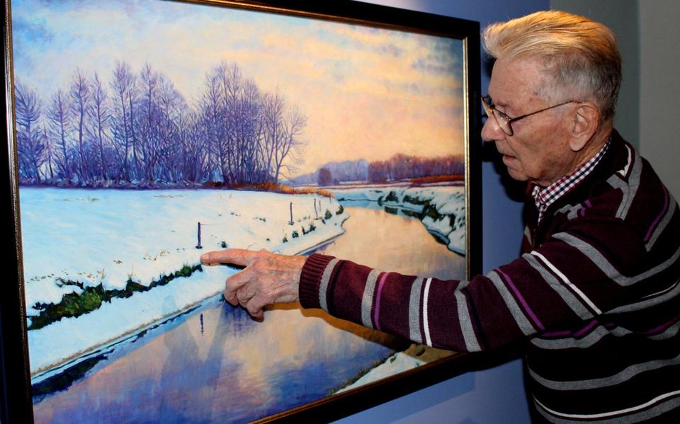 Bé Kracht bij zijn schilderij van het Peizerdiepje in de winter.