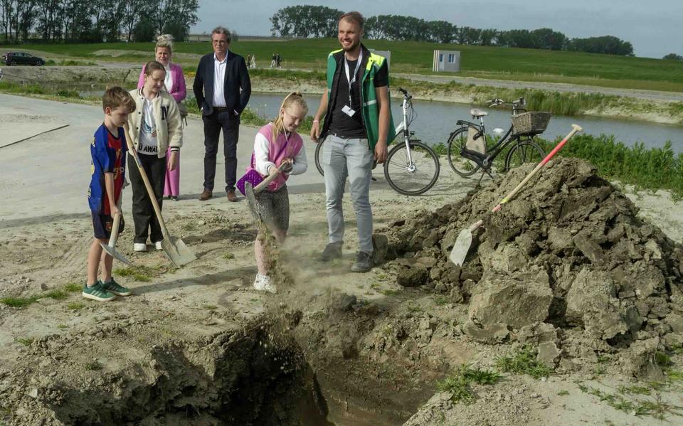 Kinderen begraven tijdcapsule, briefjes en kranten bij nieuwe woonwijk Oostergast.