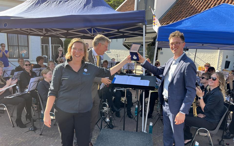 Vol trots tonen voorzitter Jantine Postma en dirigent Stefan de Groot van CMV Juliana uit Aduard de koninklijke erepenning die zij ontvingen.