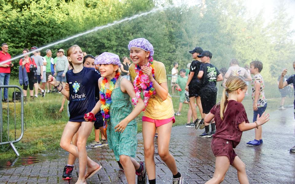 De spuitgasten van de brandweer bezorgen de wandelaars van de Roder Avondvierdaagse een kletsnat slot.
