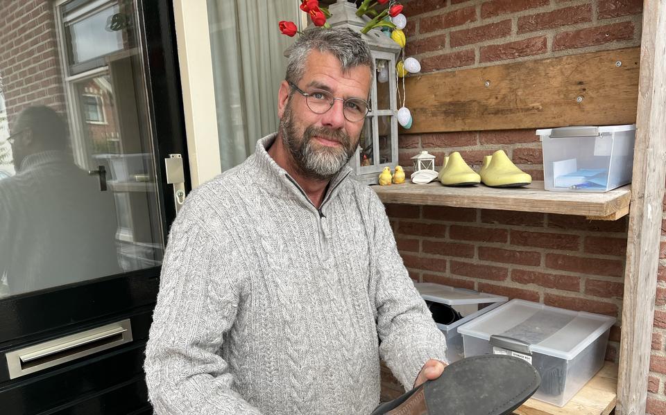 Schoenmaker Pieter de Ruiter bij de plastic bakken bij de voordeur van zijn huis in Noordhorn. Klanten kunnen te repareren schoenen hierin deponeren.