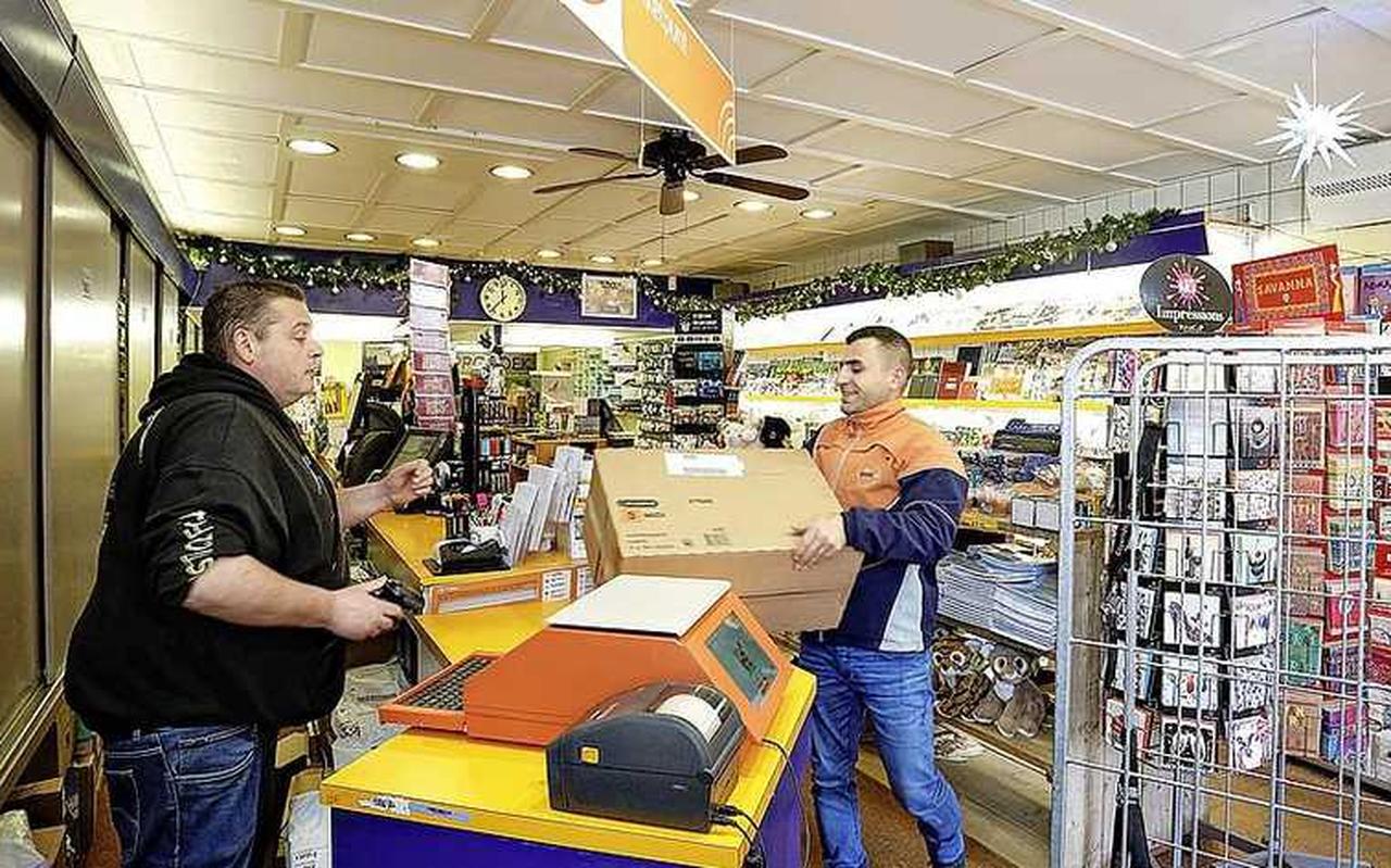 Een medewerker van PostNL levert een pakket af. Een medewerker van PostNL levert een pakket af.