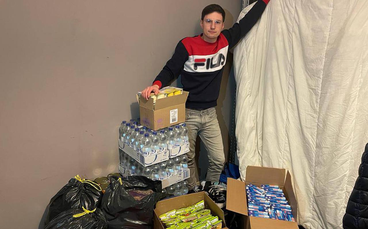 Anton Rashchenko (27) uit Groningen naast ingezamelde spullen voor vluchtelingen uit Oekraïne.
