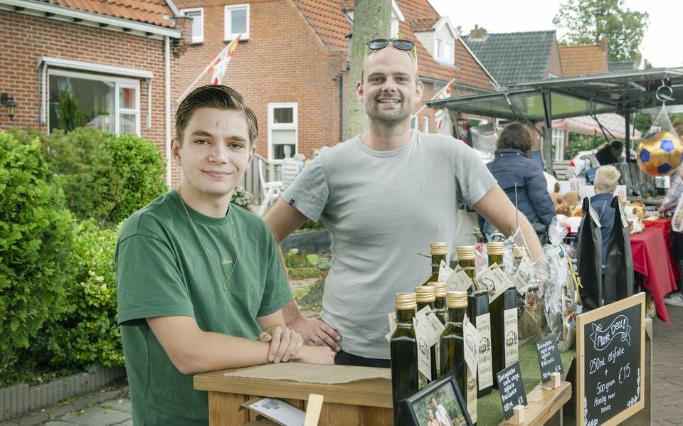 Sym-Jan de Vries (links) met zijn partner Remi Haverman verkopen olijfolie uit Spanje op de jaarmarkt in Buitenpost. 