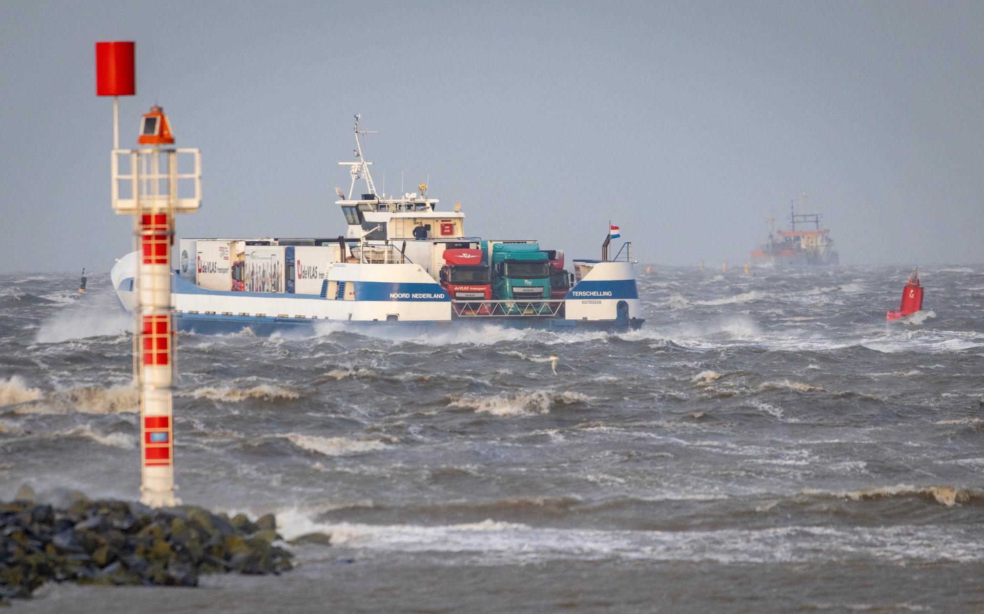De vrachtboot van Harlingen naar Terschelling werkt zich door de harde wind en over de hoge golven.