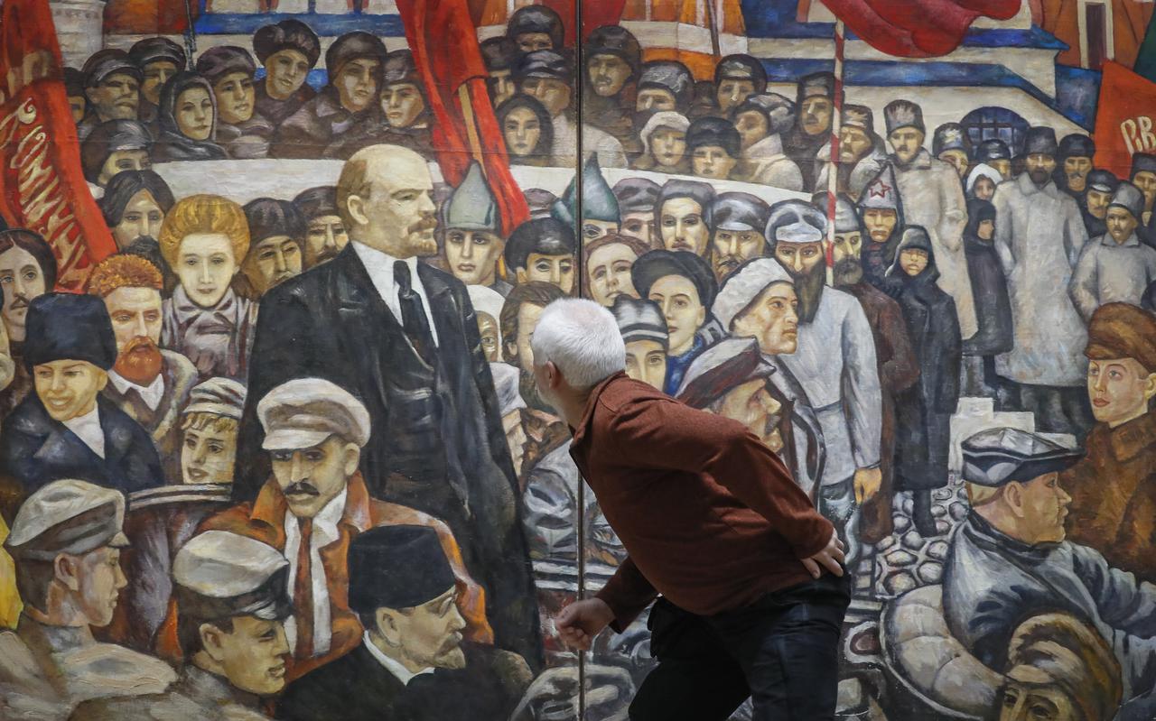 Een bezoeker bekijkt het tweeluik 'Revolution' met de stichter van de Sovjet-Unie Vladimir Ulyanov, beter bekend als Lenin door kunstenaar Gennady Myznikov op de tentoonstelling 'USSR 100' in de New Tretyakov Gallery in Moskou. Foto: EPA