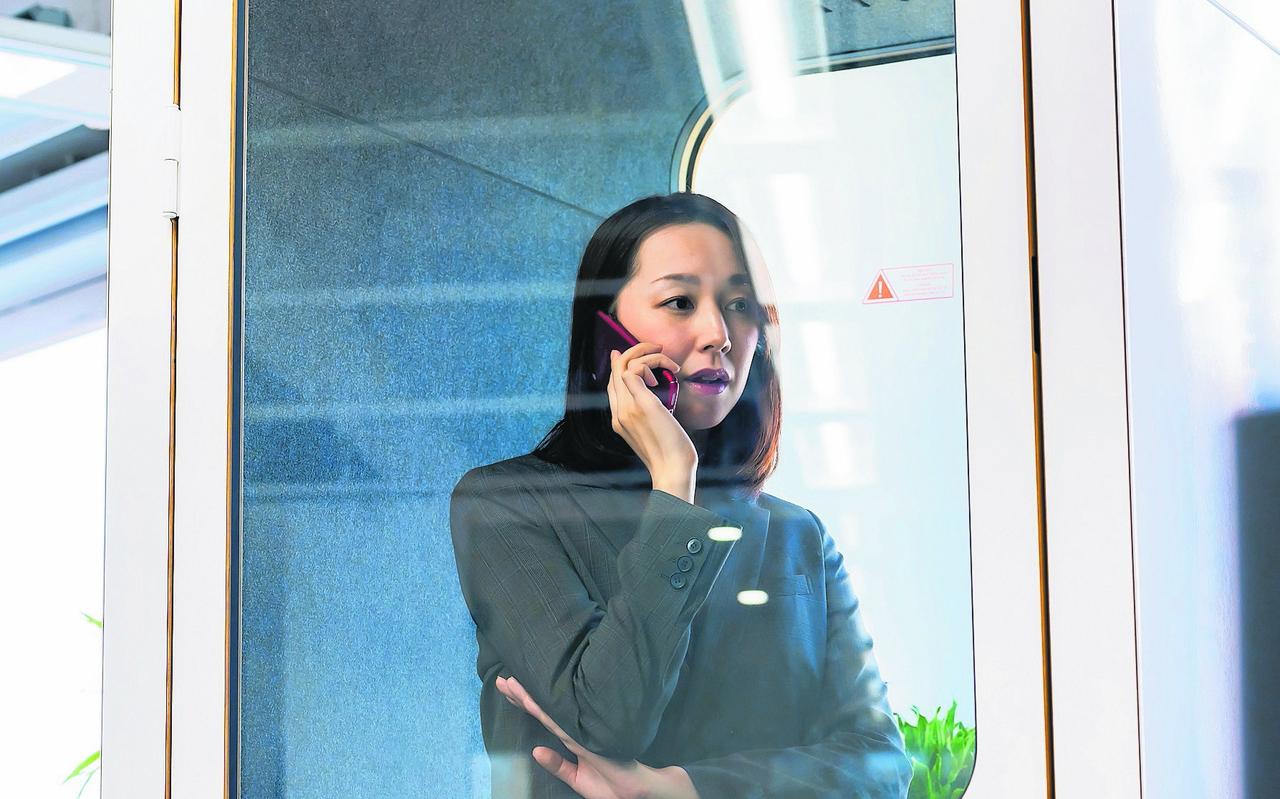Asian businesswoman calling in individual work booth. Asian businesswoman calling in individual work booth.