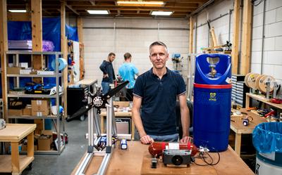 Pieter Lantermans in de werkplaats van HyFly, met voor zich een testopstelling voor de aandrijving van een propeller, een waterstoffles en een brandstofcel. FOTO JILMER POSTMA