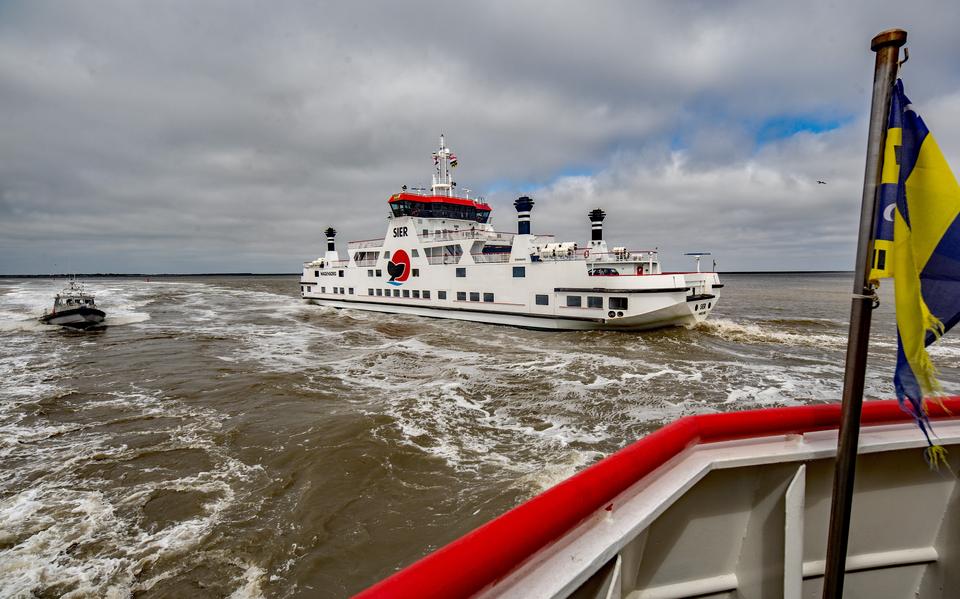Twee veerboten en de watertaxi passeren elkaar in de nauwe vaargeul van en naar Ameland. 